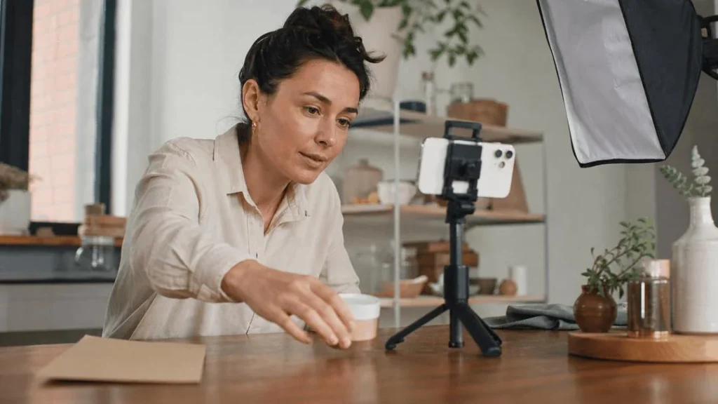 Creator recording a product demonstration with a smartphone, tripod and studio light